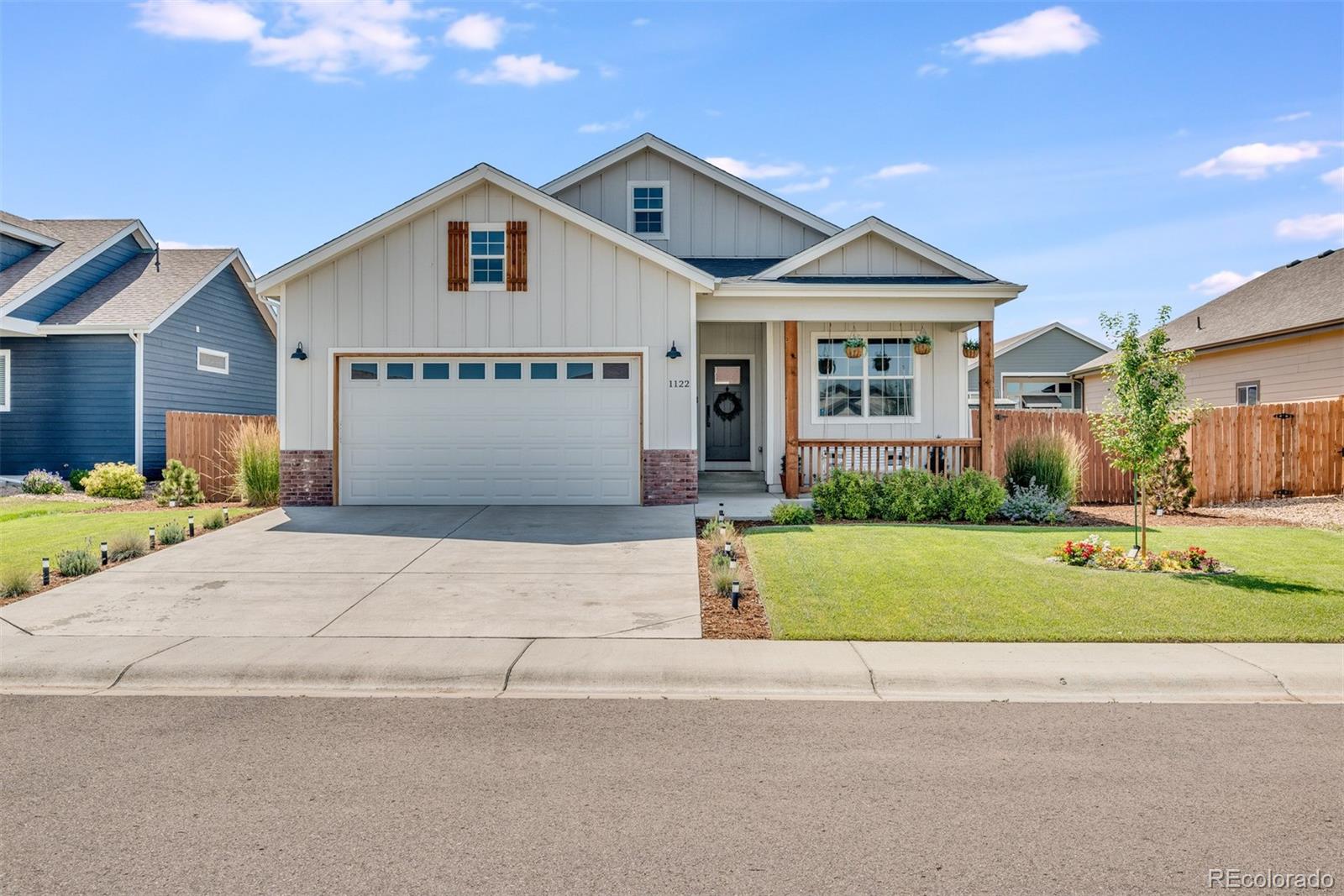 1122 Johnson Street Wiggins, CO 80654 - Photo 1 of 37 a front view of a house with a garden and garage