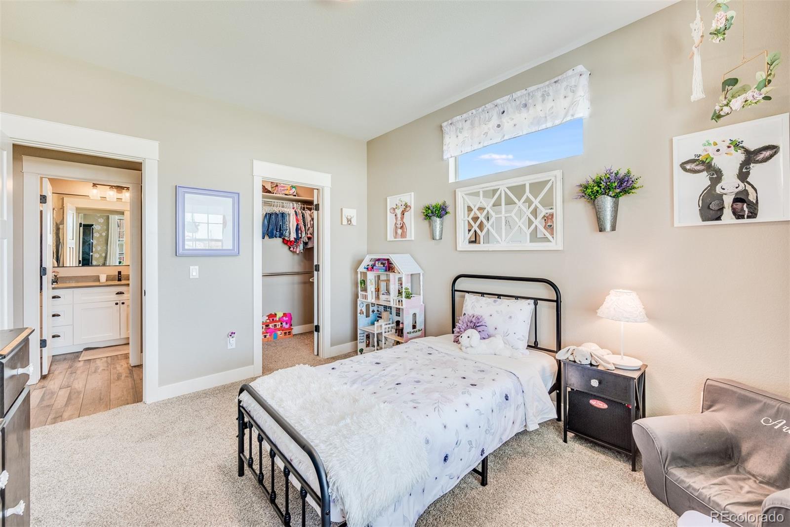 1122 Johnson Street Wiggins, CO 80654 - Photo 13 of 37 a bedroom with a large bed and a chandelier