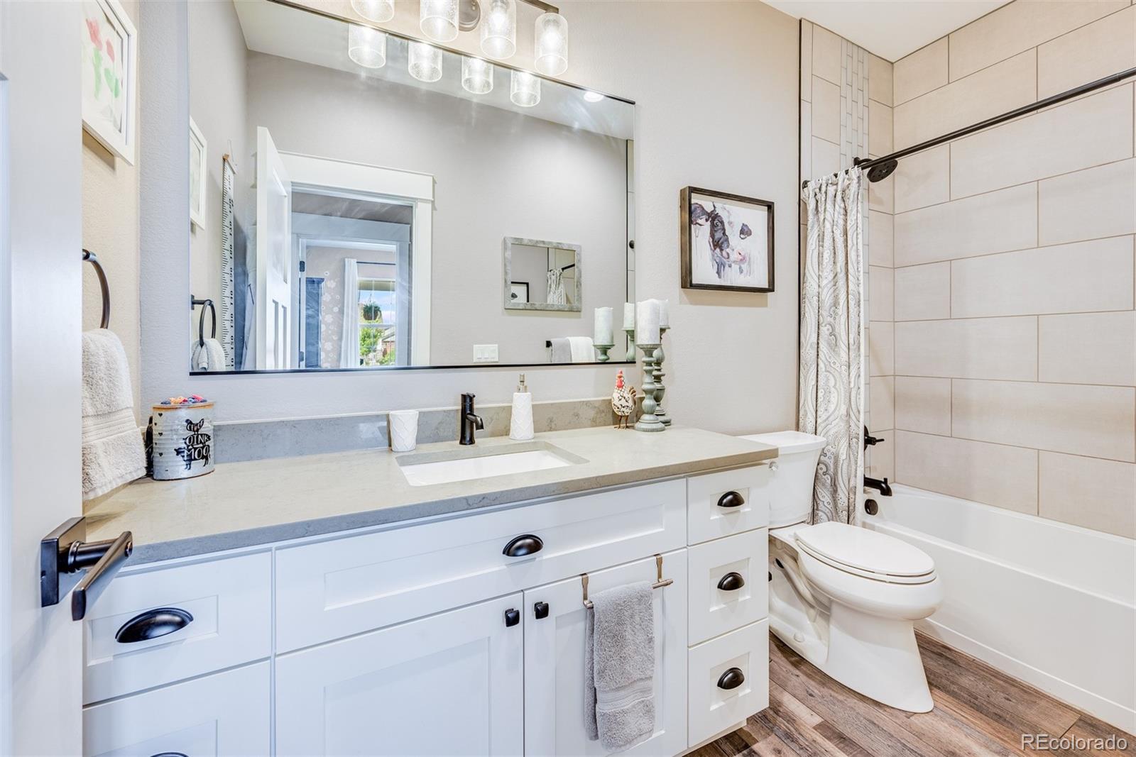 1122 Johnson Street Wiggins, CO 80654 - Photo 18 of 37 a bathroom with a double vanity sink toilet mirror and shower