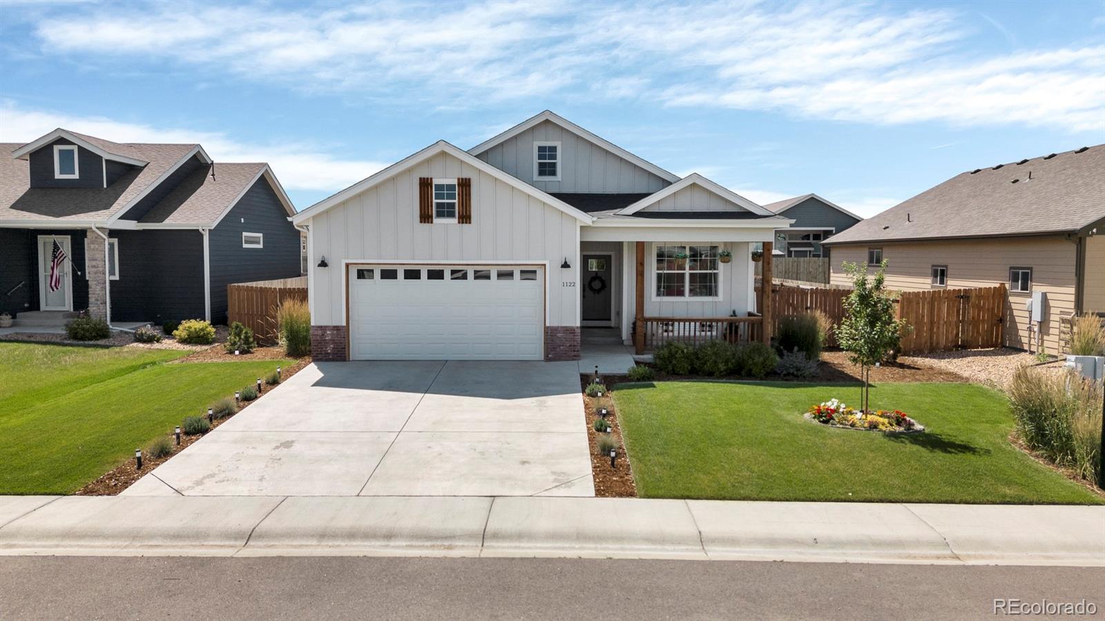 1122 Johnson Street Wiggins, CO 80654 - Photo 2 of 37 a front view of a house with a yard and garage