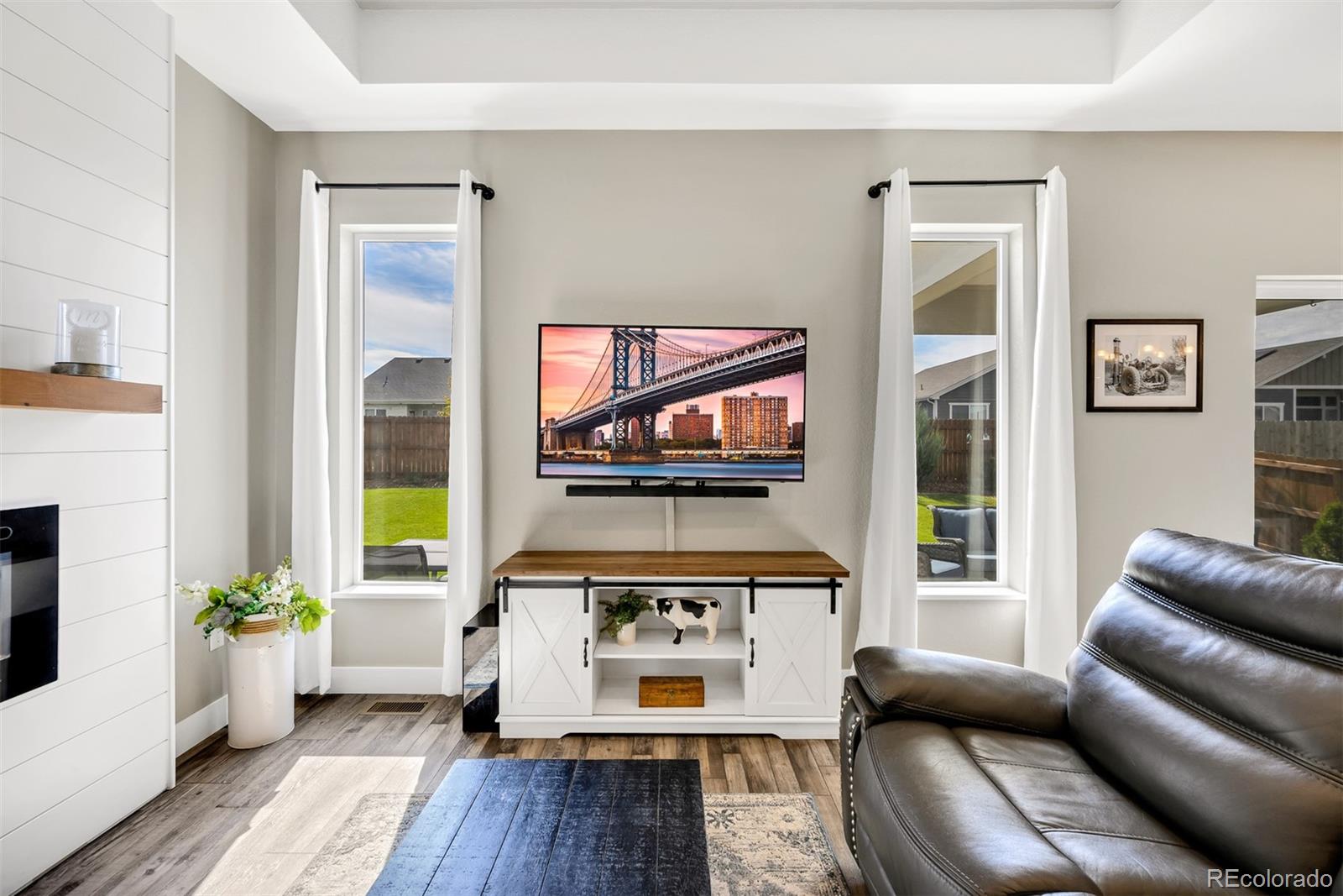 1122 Johnson Street Wiggins, CO 80654 - Photo 24 of 37 a living room with furniture and a flat screen tv