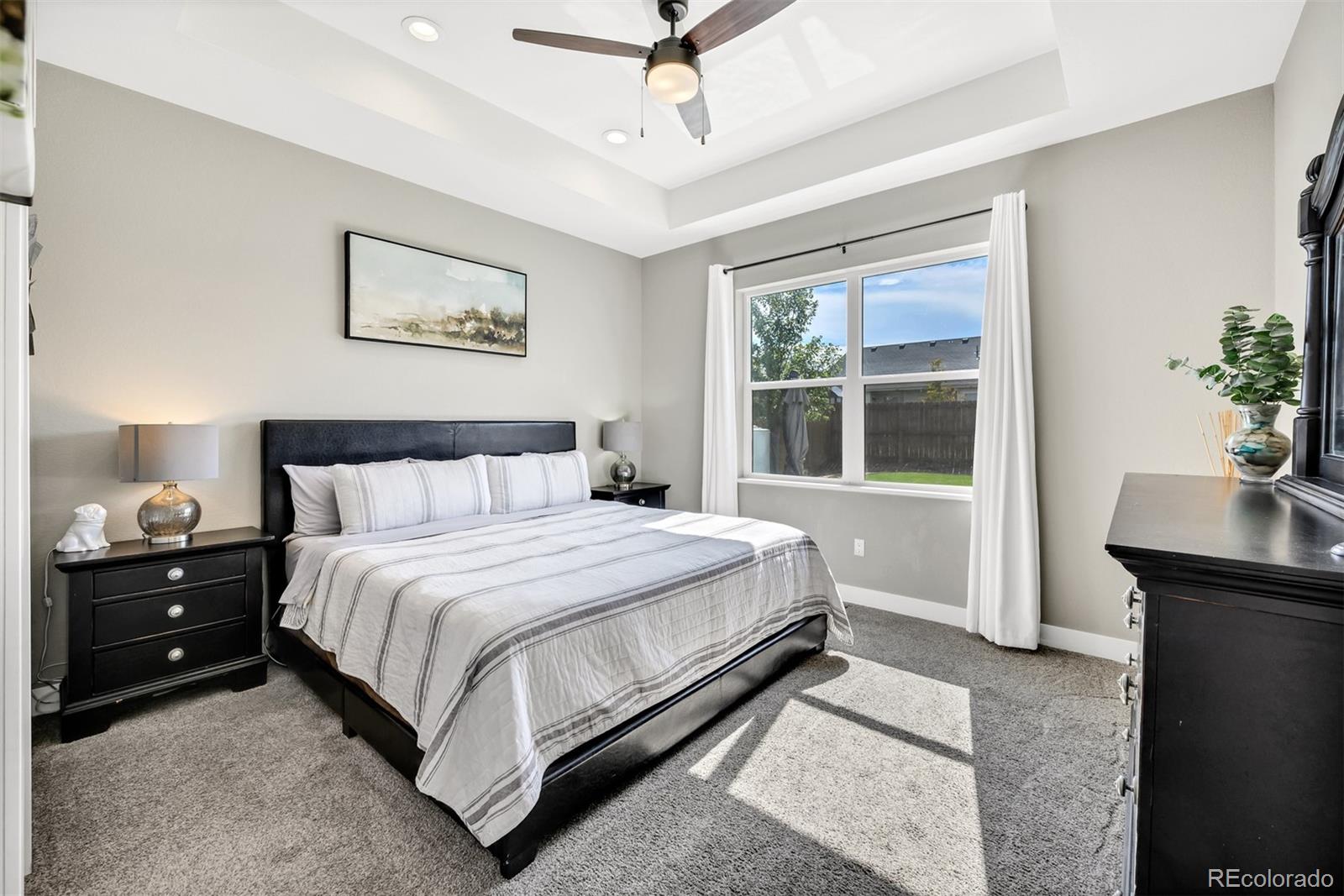 1122 Johnson Street Wiggins, CO 80654 - Photo 27 of 37 a bedroom with a bed and a potted plant on the dresser