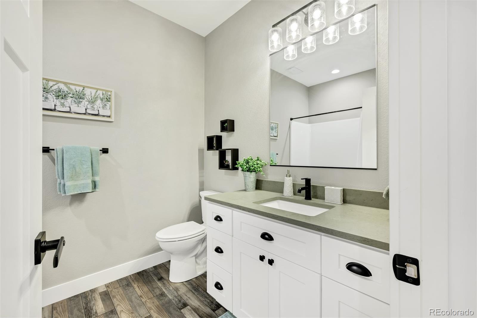 1122 Johnson Street Wiggins, CO 80654 - Photo 30 of 37 a bathroom with a granite countertop sink mirror and toilet