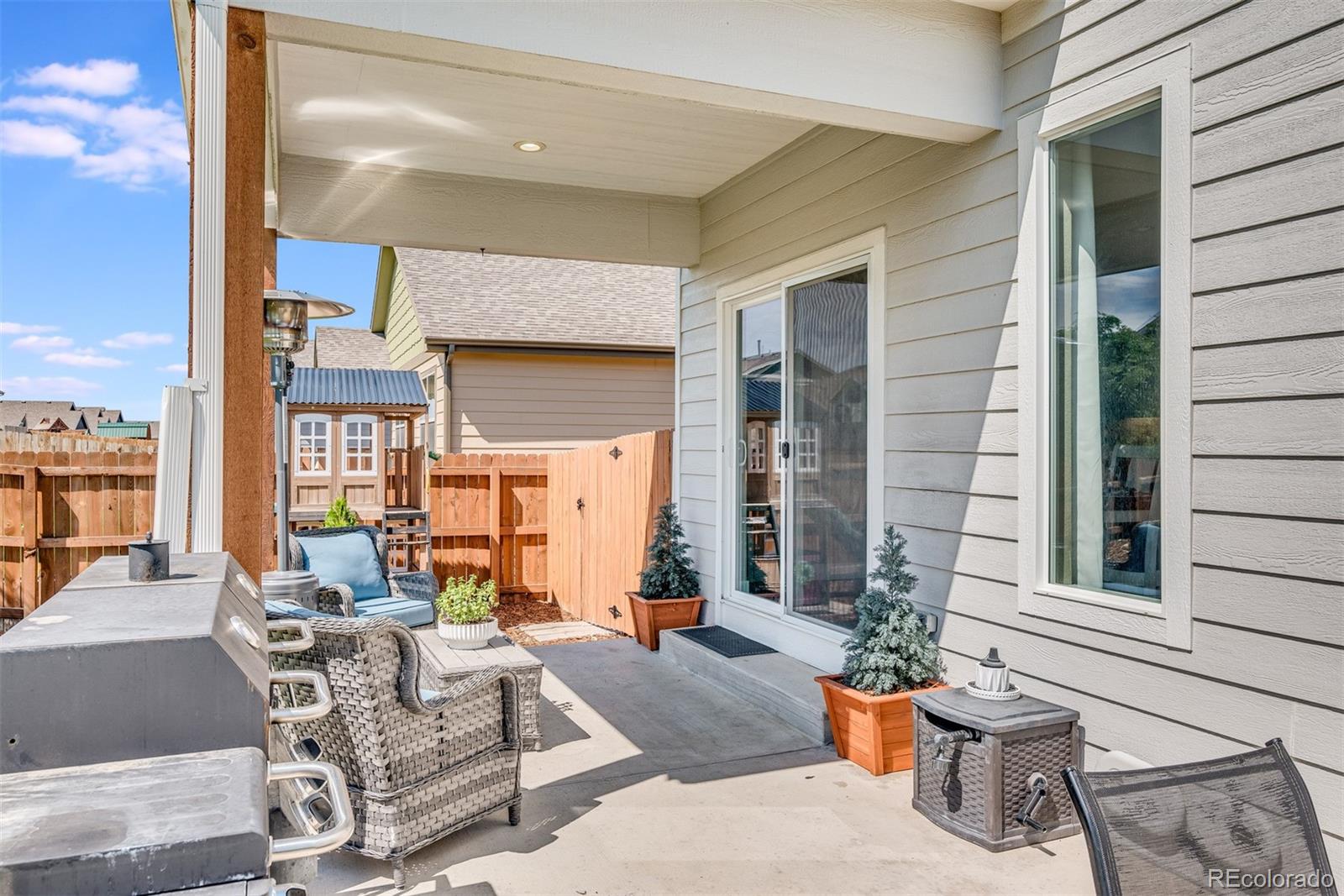 1122 Johnson Street Wiggins, CO 80654 - Photo 9 of 37 a view of a patio with dining table and chairs and potted plants