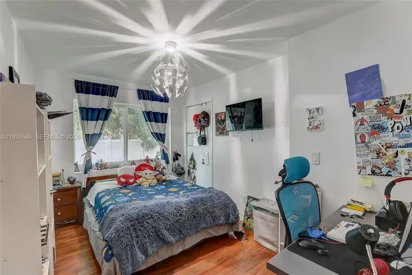 a bedroom with bed and a chandelier