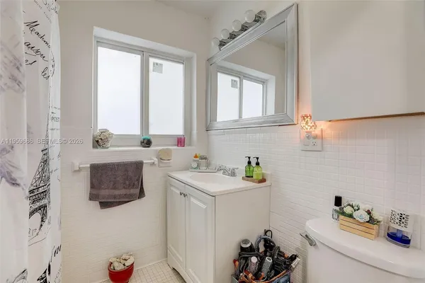 a bedroom with a bed and a flat tv screen on the dresser
