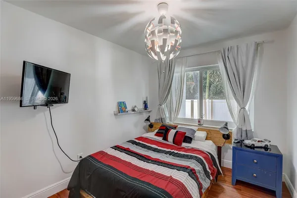 a bedroom with a bed and wooden floor