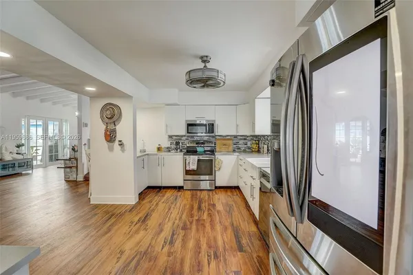 a kitchen with a refrigerator and wooden floor