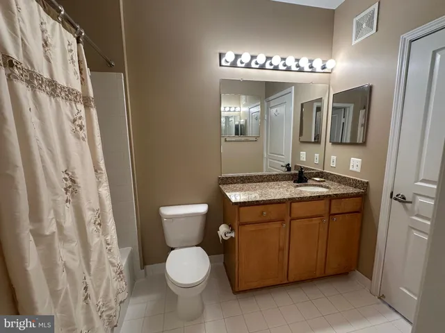 a living room with lots of furniture and a view of kitchen