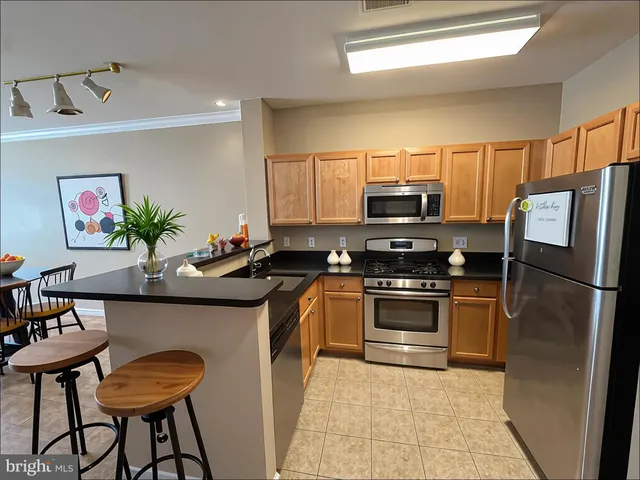 a kitchen with stainless steel appliances granite countertop a refrigerator a stove a sink and a microwave