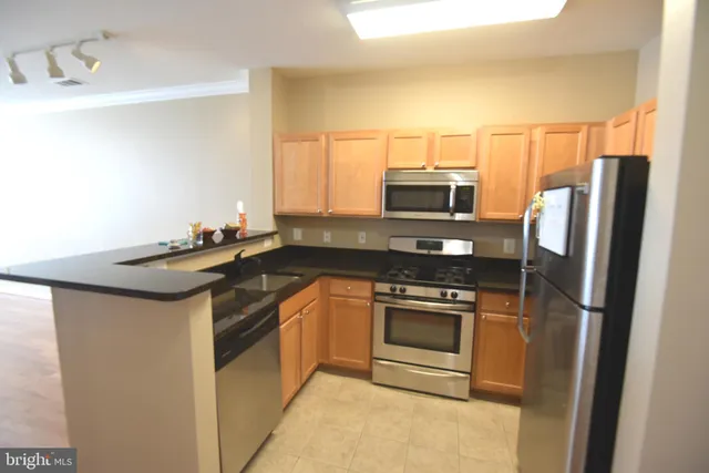 a kitchen with granite countertop a sink stove and refrigerator