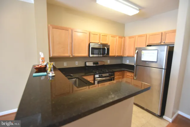 a kitchen with kitchen island a counter top space appliances a sink and a window