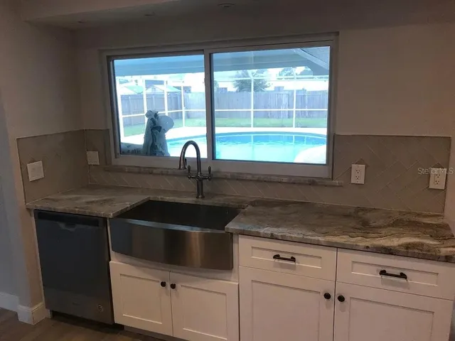 a kitchen with granite countertop a sink and a window