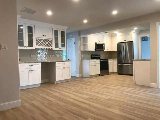 a kitchen with stainless steel appliances a refrigerator and a stove top oven