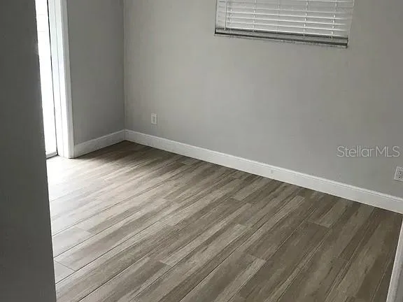 a view of a room with wooden floor and windows