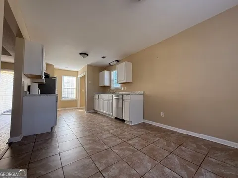 a kitchen with granite countertop a sink a stove top oven and cabinets