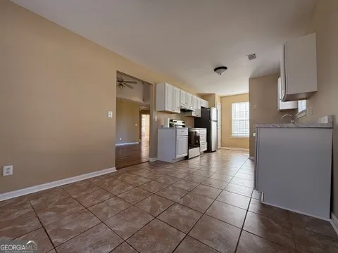 a kitchen with granite countertop a refrigerator and a stove top oven