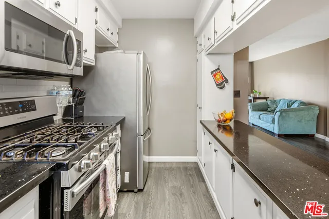 a kitchen with stainless steel appliances granite countertop a stove and a refrigerator
