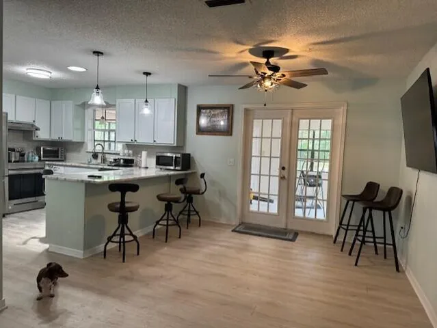 a view of a dining room with furniture and a chandelier fan