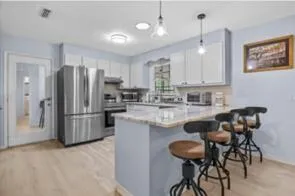 a kitchen with stainless steel appliances kitchen island granite countertop a refrigerator and a stove top oven