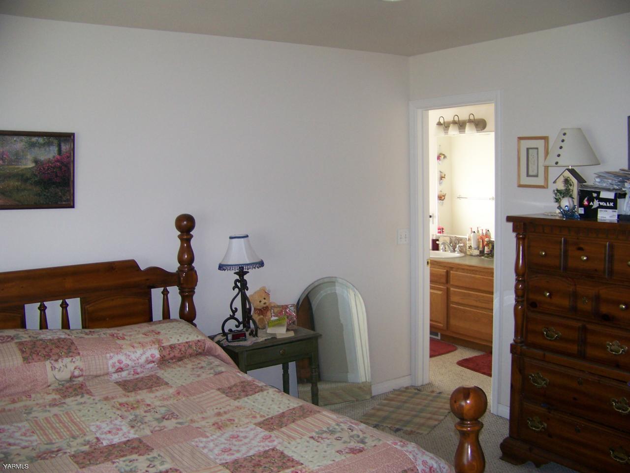 10811 Zier Road Yakima, WA 98908 - Photo 12 of 20 a bedroom with a bed and wooden floor