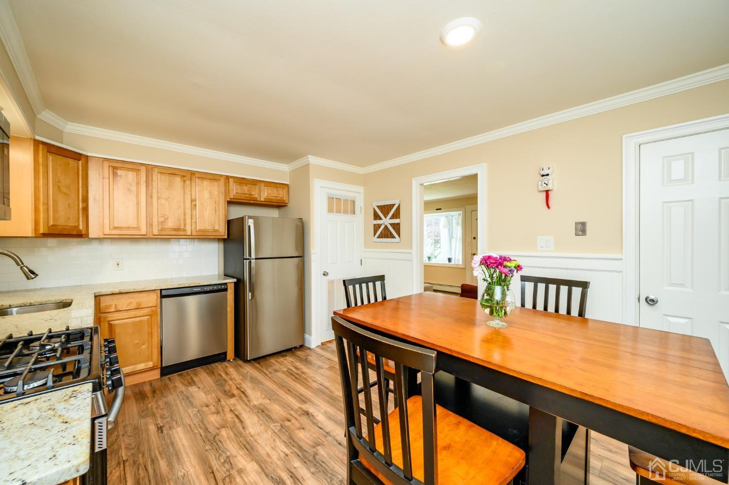 217 Clamer Road Ewing, NJ 08628 - Photo 9 of 29 a kitchen with stainless steel appliances granite countertop a kitchen island a stove a refrigerator a dining table and chairs with wooden floor