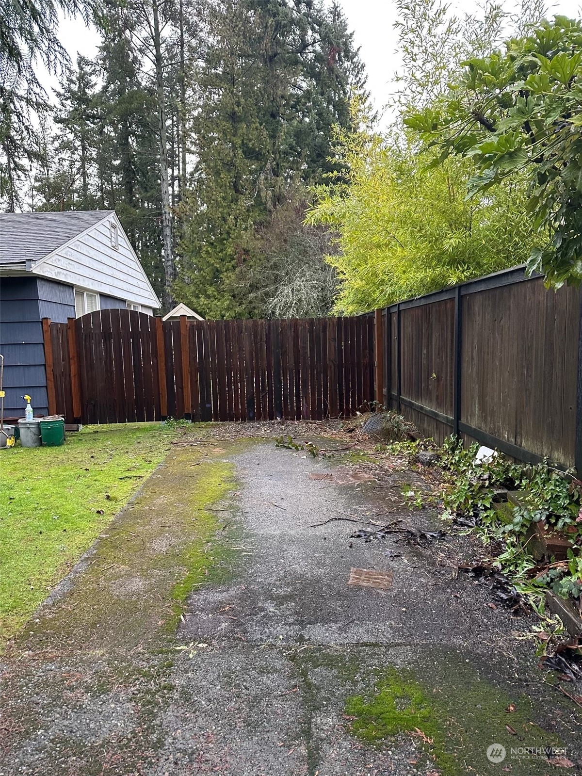 a view of small backyard with wooden fence