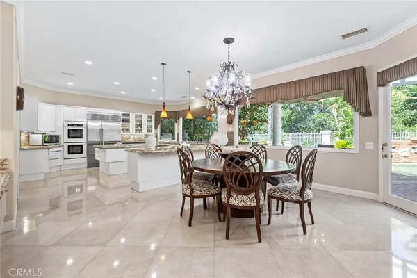 a dining room with furniture a chandelier and wooden floor