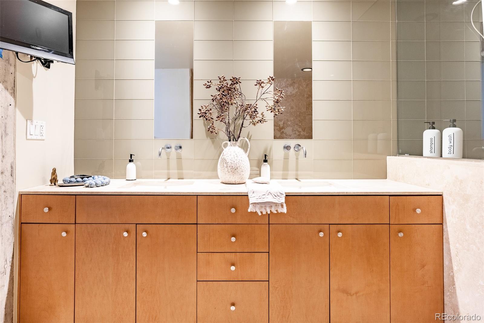1890 Wynkoop Street, Unit 604 Denver, CO 80202 - Photo 25 of 26 a bathroom with a sink and a mirror