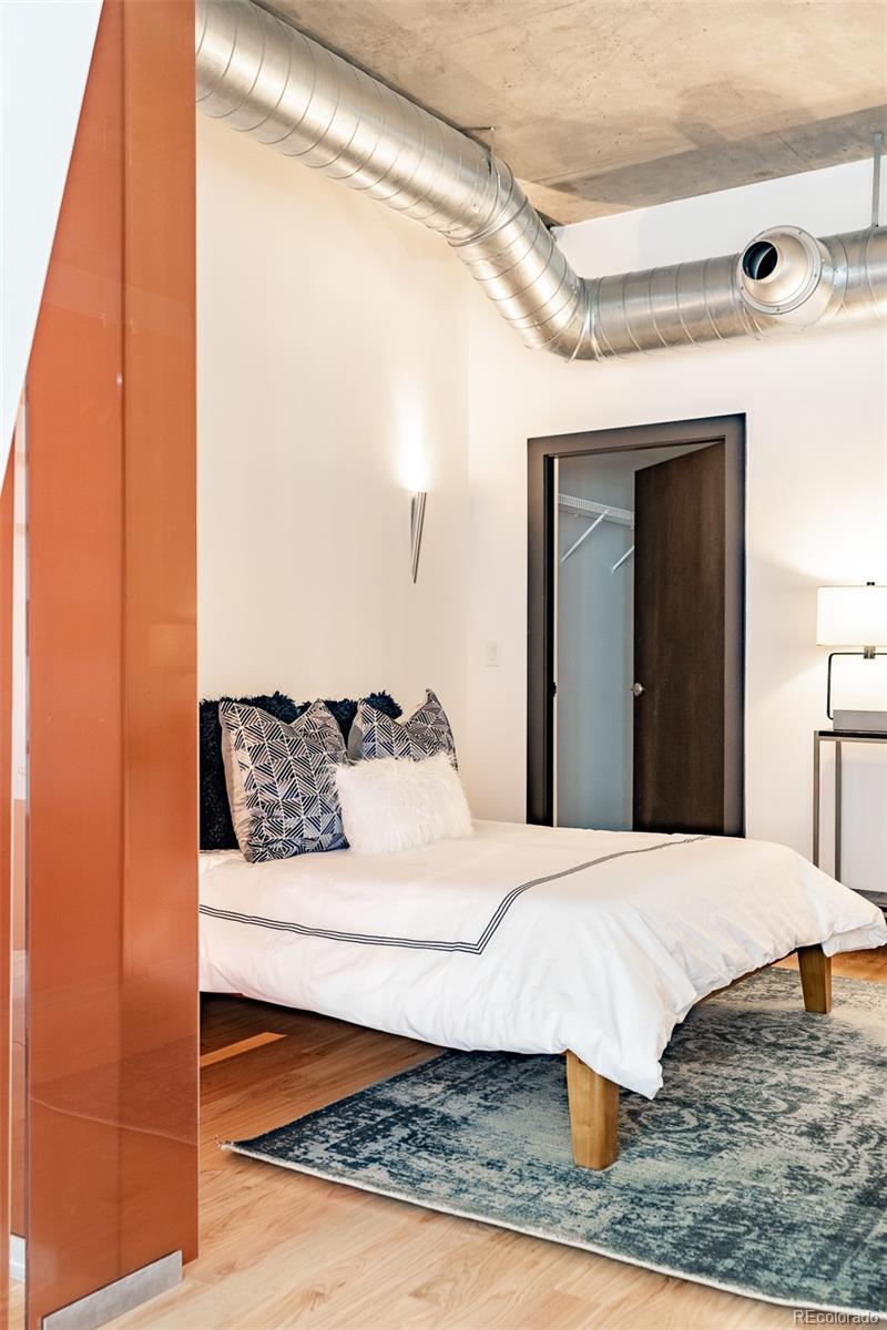 1890 Wynkoop Street, Unit 604 Denver, CO 80202 - Photo 8 of 26 a bedroom with a large bed and a dresser