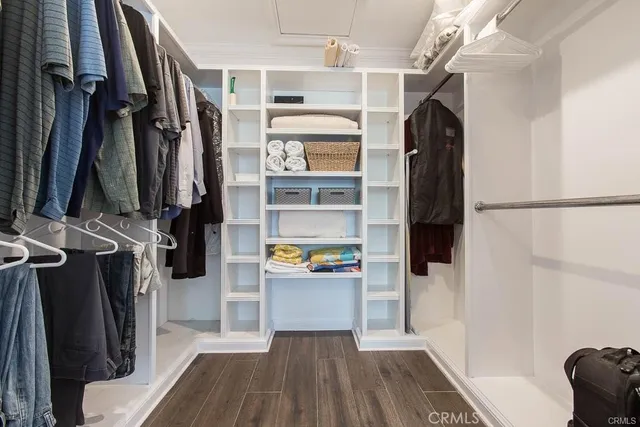 a view of walk in closet with clothes and shoes