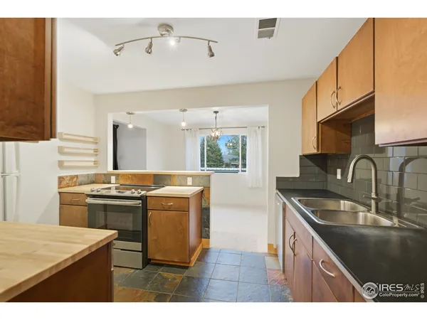 a kitchen that has a sink a stove and a refrigerator
