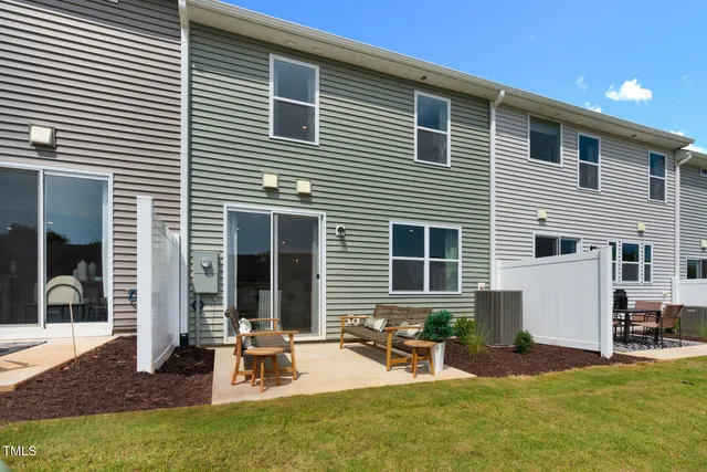 a kitchen with stainless steel appliances kitchen island granite countertop a stove a refrigerator a kitchen island a couches and chairs