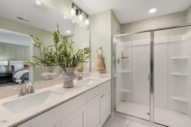 a bathroom with double vanity and a mirror