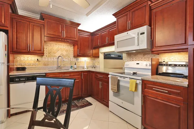 a kitchen with stainless steel appliances granite countertop wooden cabinets a stove top oven a sink and dishwasher