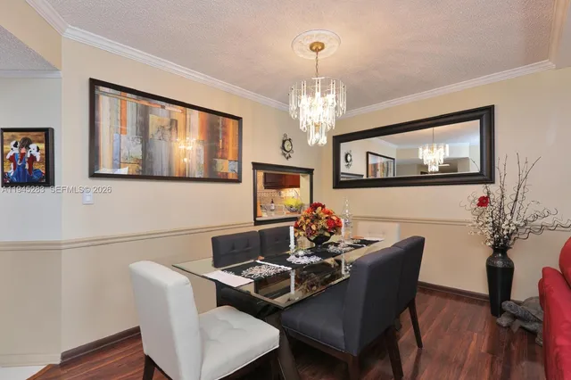 a view of a dining room with furniture wooden floor and chandelier
