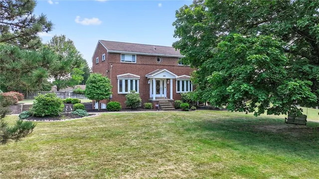 a front view of a house with a garden