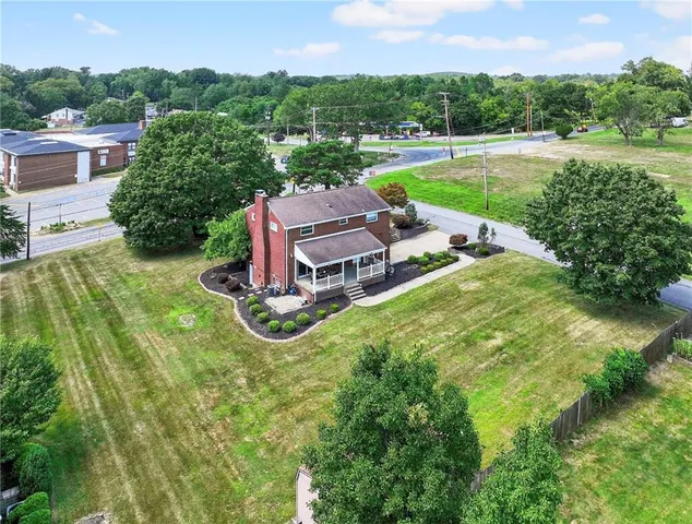 an aerial view of a house with a garden and lake view