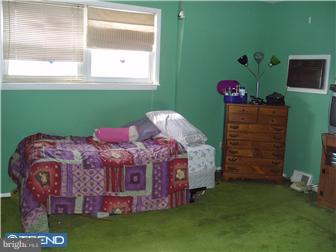 841 Avon Road Philadelphia, PA 19116 - Photo 7 of 12 a bed sitting in a bedroom next to a window