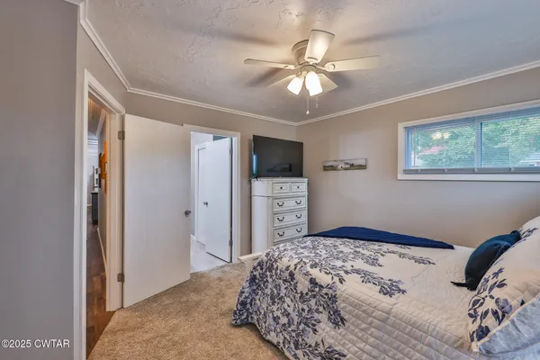 a bedroom with a large bed and a chandelier