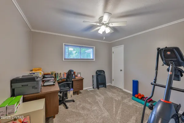 a view of a workspace with furniture and a window