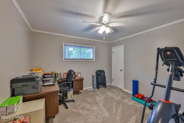 a view of a workspace with furniture and a window