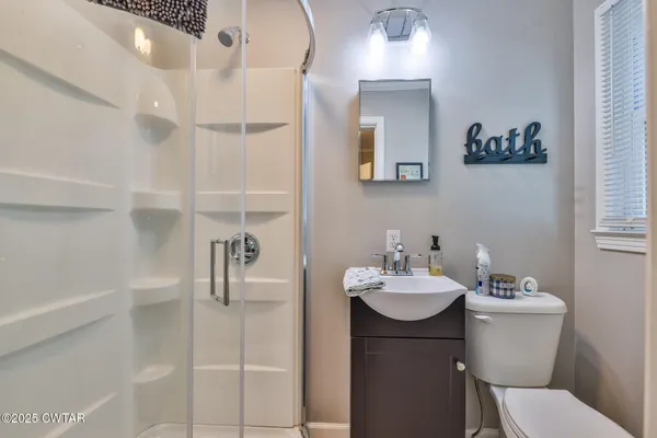 a bathroom with a sink a toilet and mirror