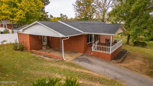 a view of a house with backyard and trees