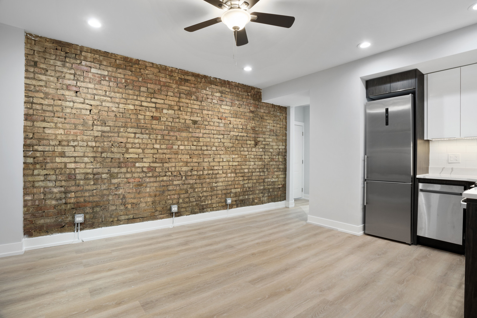 1552 West Juneway Terrace, Unit 3E Chicago, IL 60626 - Photo 3 of 13 a view of an empty room with wooden floor and a kitchen