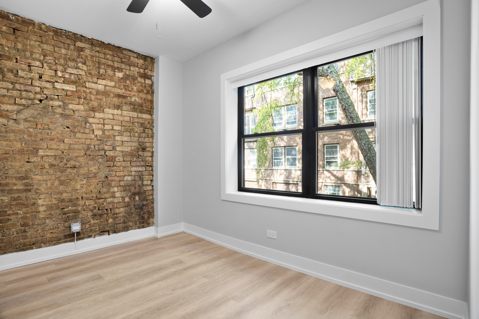 1552 West Juneway Terrace, Unit 3E Chicago, IL 60626 - Photo 9 of 13 a view of an empty room with a window and a kitchen