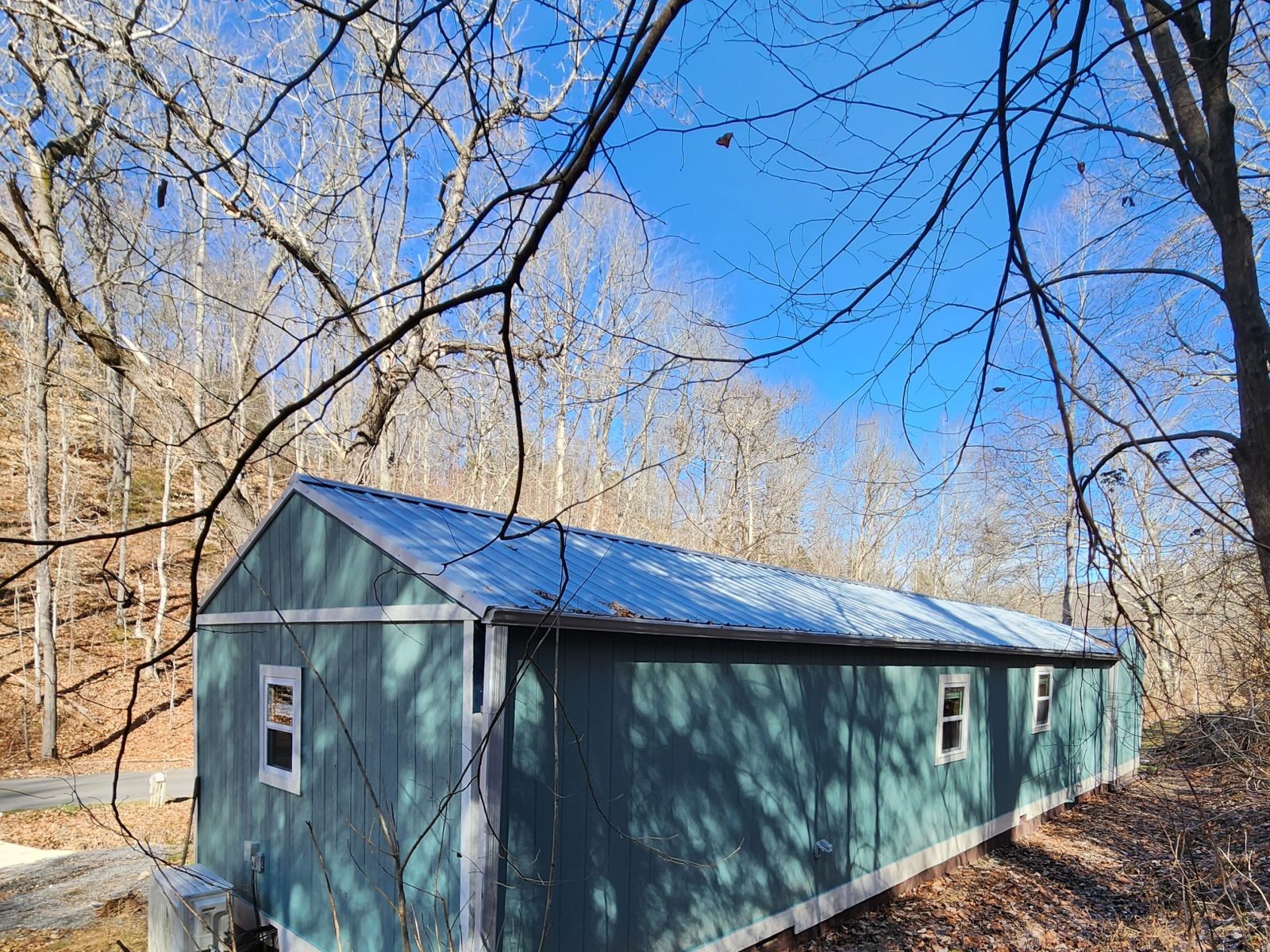 2179 Hackney Road Greenbrier, TN 37073 - Photo 3 of 20 a view of a wooden house with a small yard and a large tree