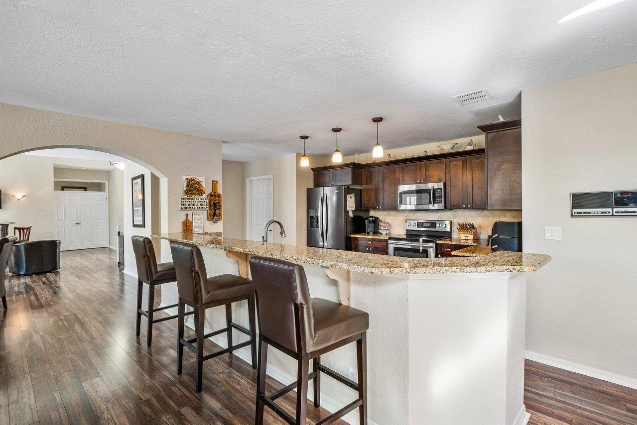 10921 Haydn Drive Boca Raton, FL 33498 - Photo 12 of 45 a kitchen with stainless steel appliances kitchen island granite countertop a table chairs and a refrigerator