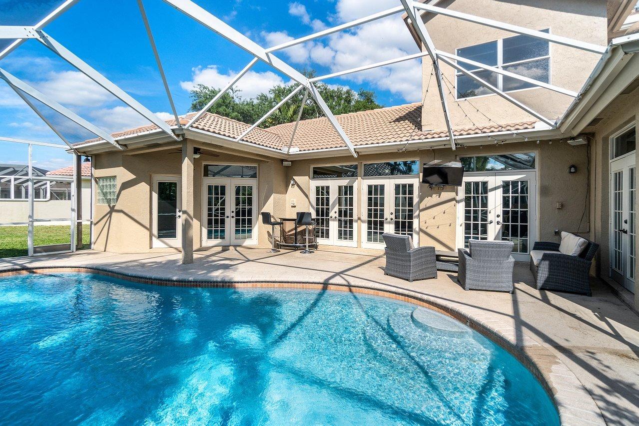 10921 Haydn Drive Boca Raton, FL 33498 - Photo 20 of 45 a view of a patio with a table and chairs under an umbrella