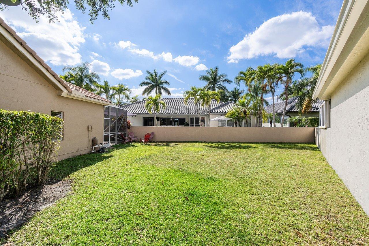 10921 Haydn Drive Boca Raton, FL 33498 - Photo 22 of 45 a view of a house with a big yard and a large tree